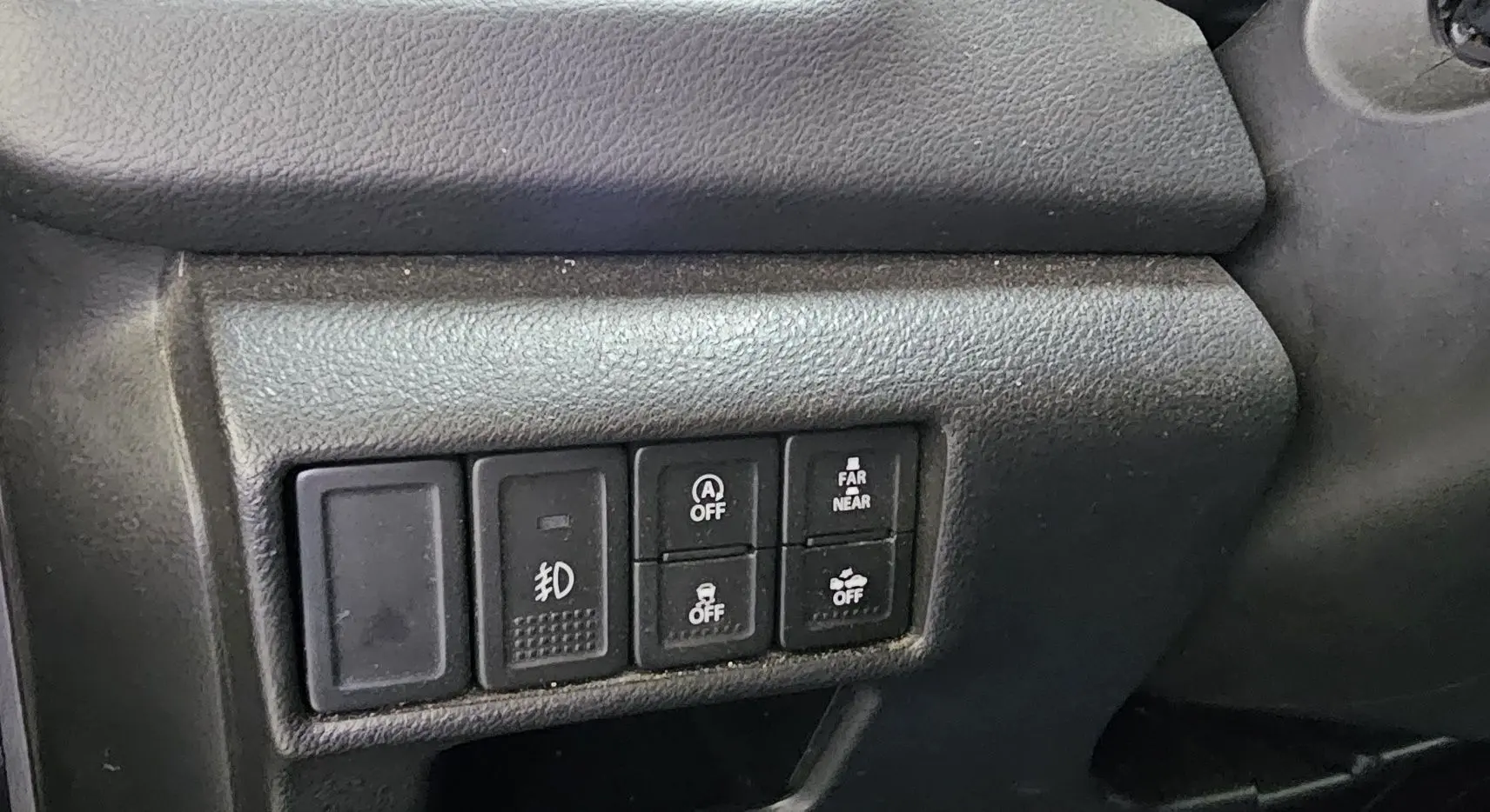 Vue rapprochée des boutons de commande sur la gauche du tableau de bord du Suzuki SX4 S-Cross gris 2020.