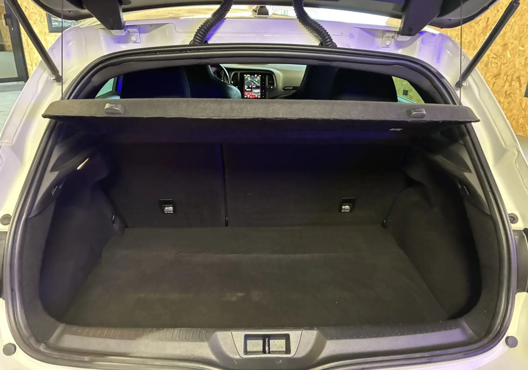 Vue intérieure de la porte arrière gauche blanche de la Renault Mégane IV RS 280 EDC6 avec insert carbone et bandeau lumineux rouge.