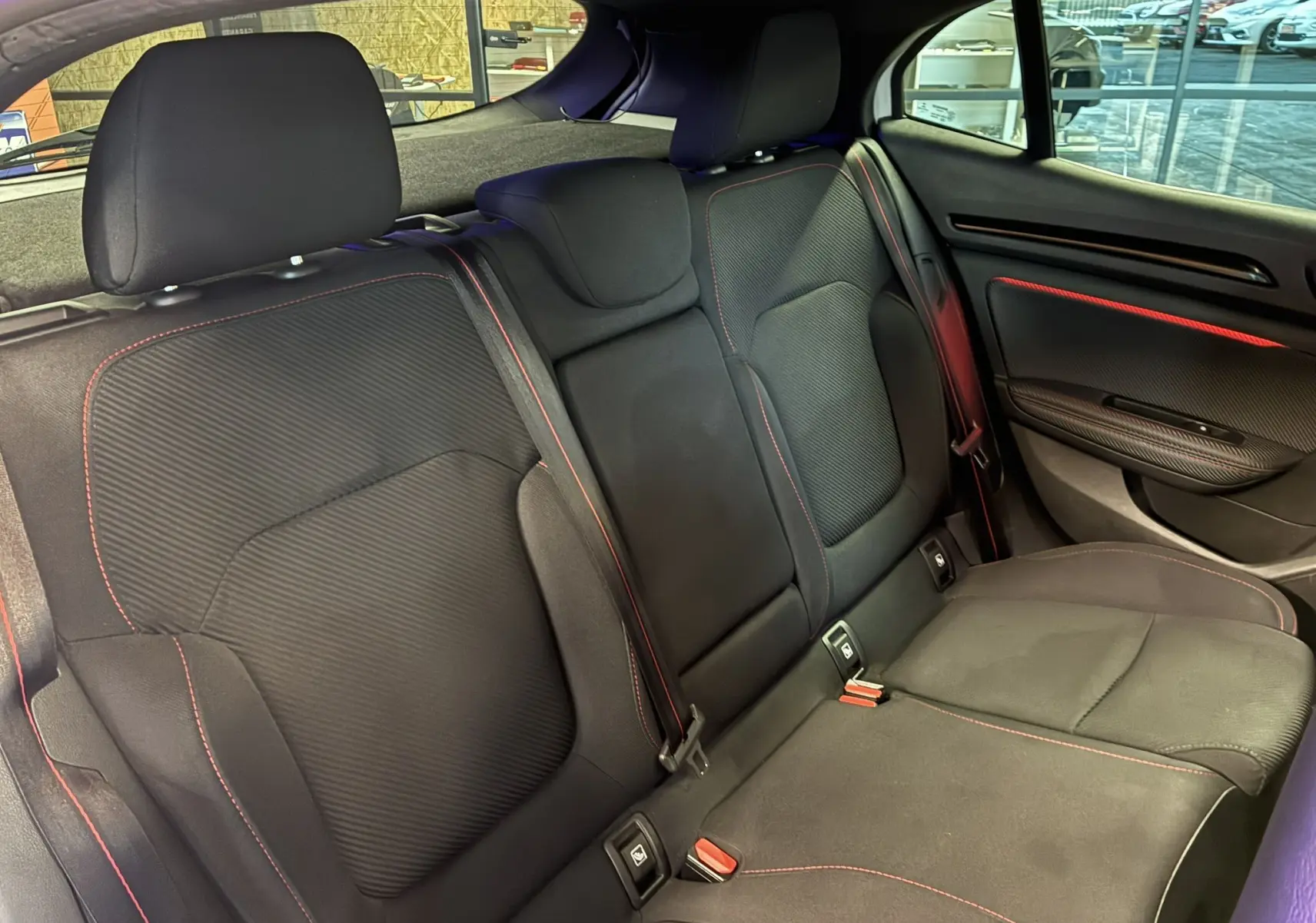 Coffre ouvert vu de l'arrière d'une Renault Mégane IV RS 280 EDC6 blanche, intérieur noir avec tablette de séparation.