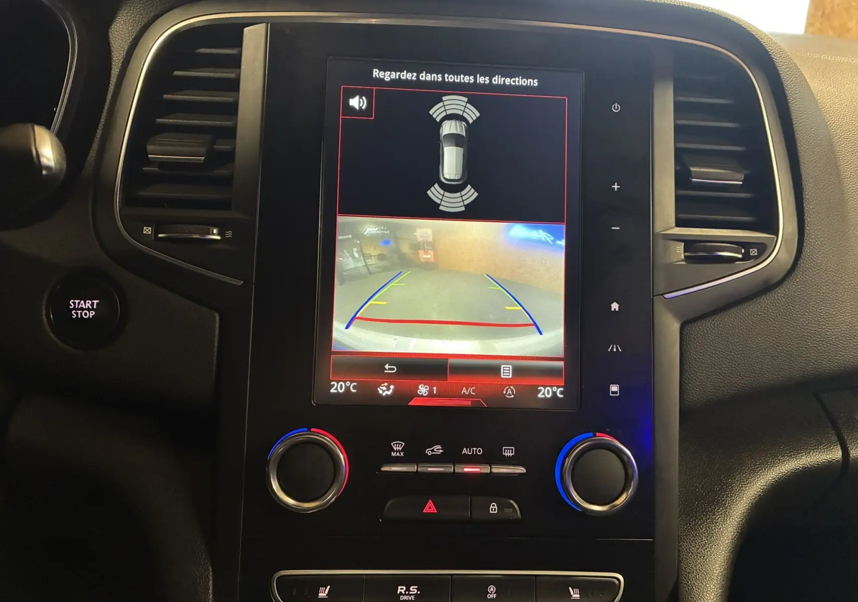 Vue rapprochée du volant et du tableau de bord rouge de la Renault Mégane IV RS 280 blanche, avec palettes au volant.