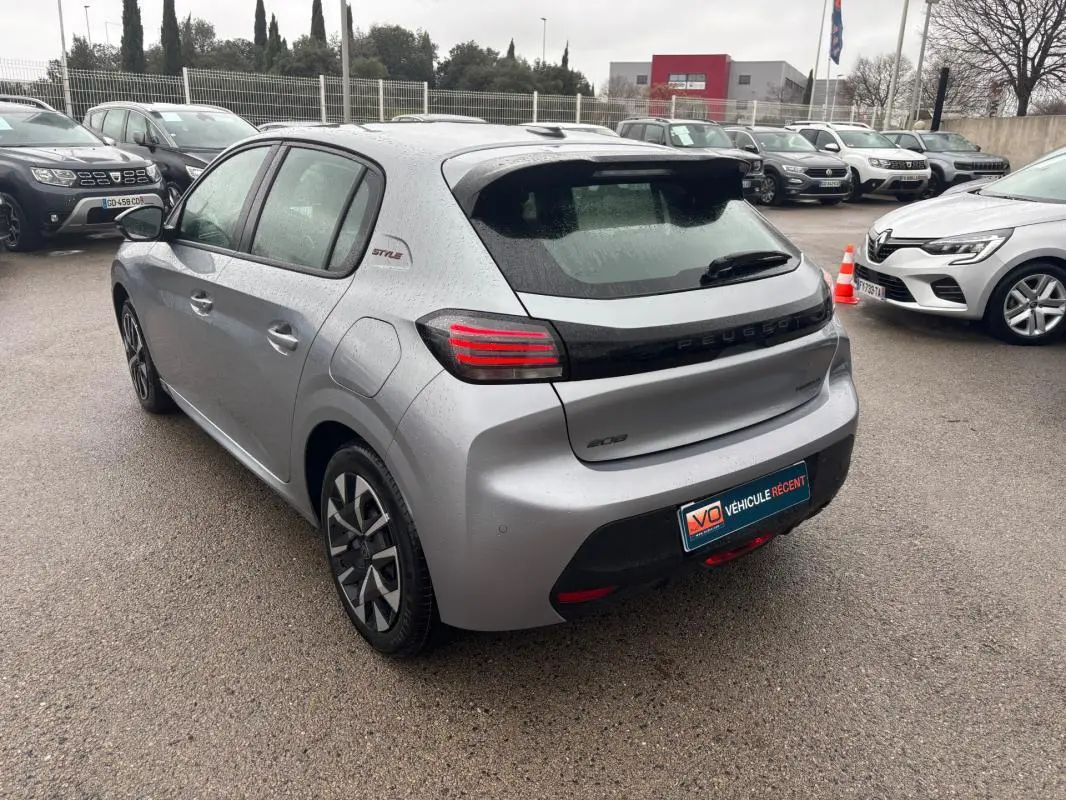 Vue 3/4 arrière droite d'une Peugeot 208 gris métallisé avec feux arrière LED et jantes 16 pouces.