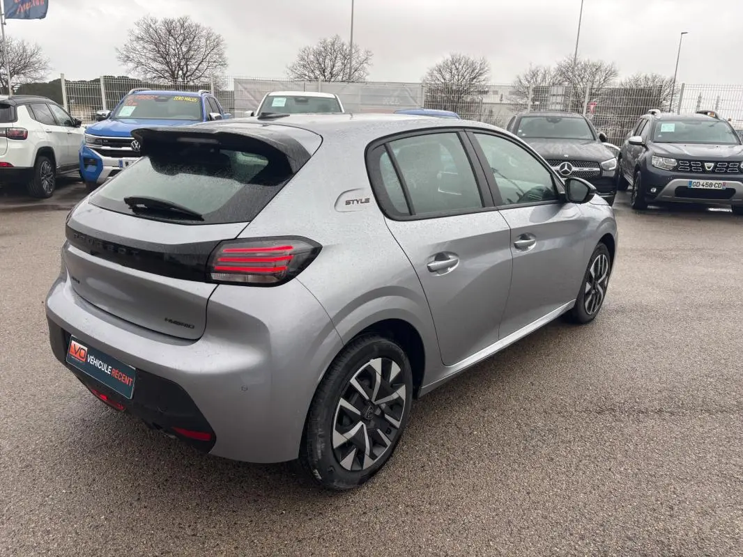 Peugeot 208 Hybrid gris vue 3/4 arrière droit, avec jantes 16 pouces et badge Style sur le côté.