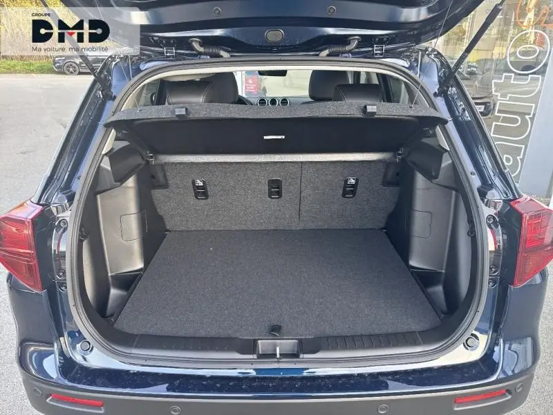 Coffre ouvert d'un Suzuki Vitara bleu So'Color Sphere, vue arrière montrant l'espace de chargement et la tablette cache-bagages.