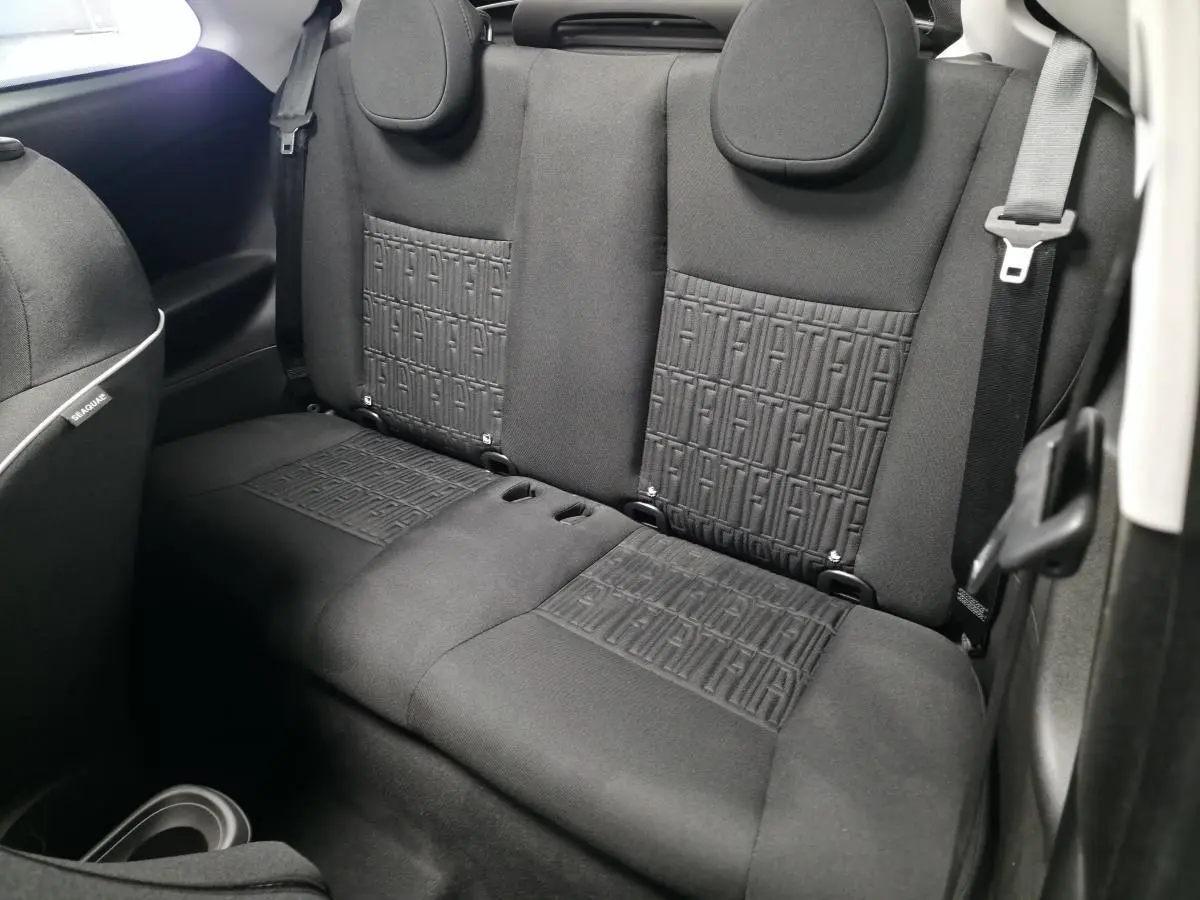 Vue intérieure arrière montrant les sièges noirs avec motifs FIAT embossés sur la banquette arrière du Fiat 500 Cabriolet.