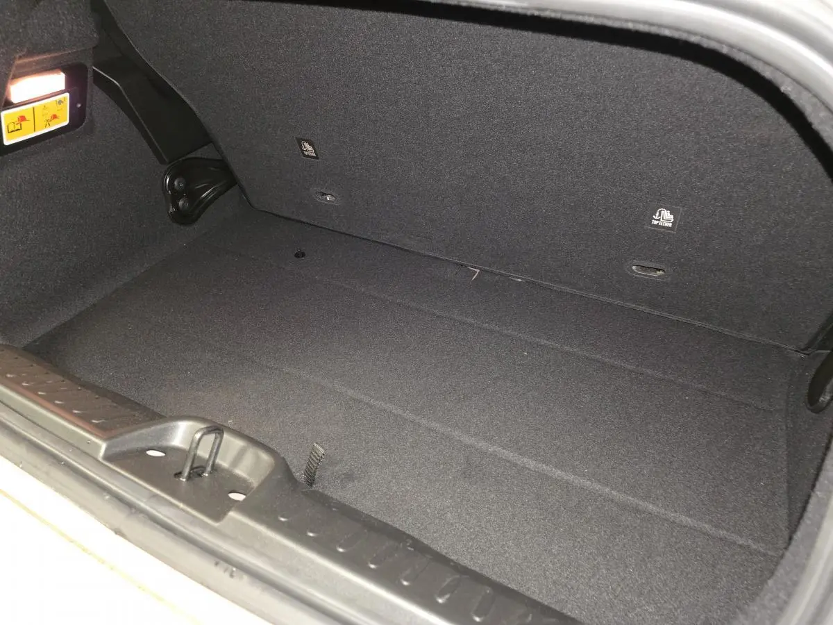 Vue rapprochée de l'intérieur du coffre noir d'une Fiat 500 Cabriolet électrique 2023, sans chargement visible.