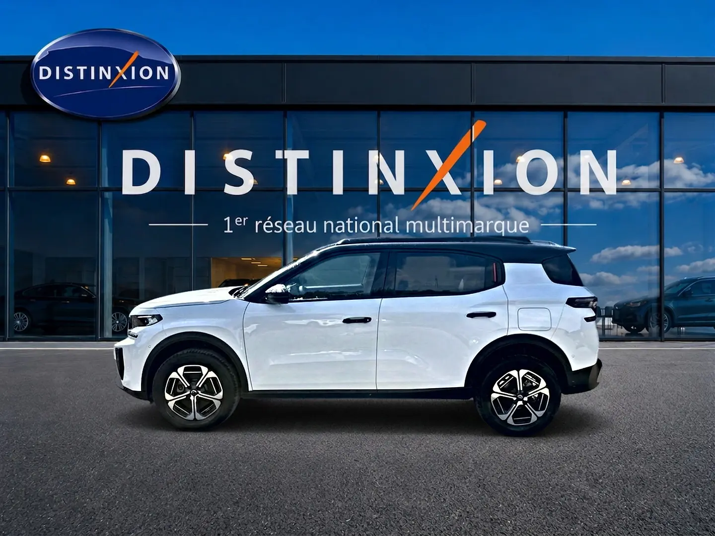 Profil côté gauche d'un Citroën C3 Aircross blanc avec toit noir, jantes alu et détails noirs contrastants.