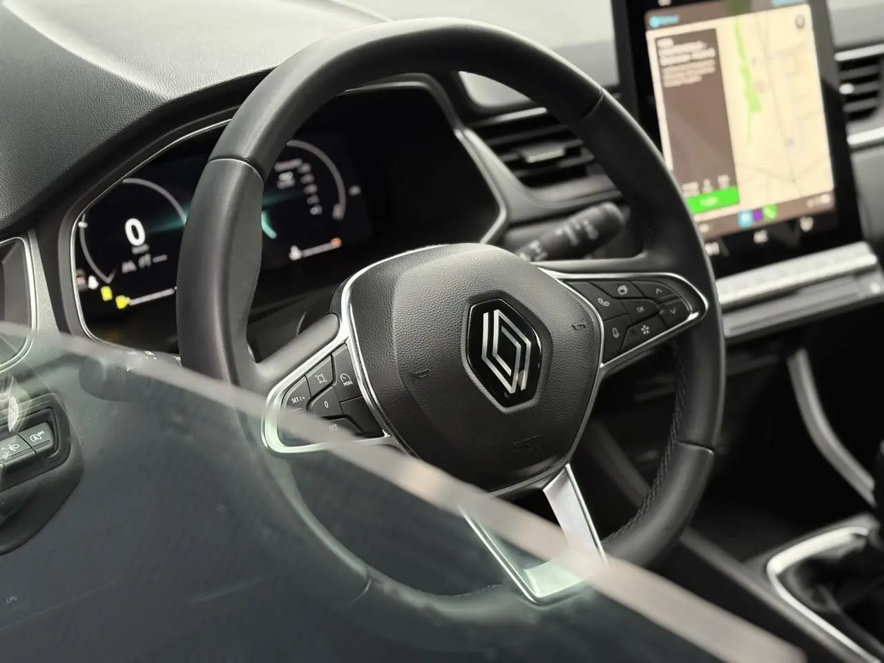 Vue rapprochée du volant noir du Renault Captur 2025 avec tableau de bord numérique et écran tactile GPS.