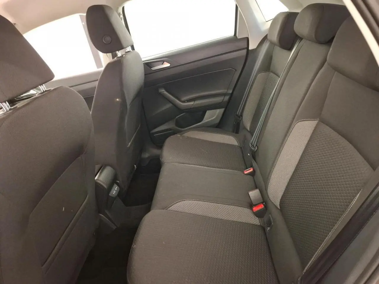 Vue latérale intérieure montrant la banquette arrière en tissu gris foncé de la Volkswagen Polo 2023.