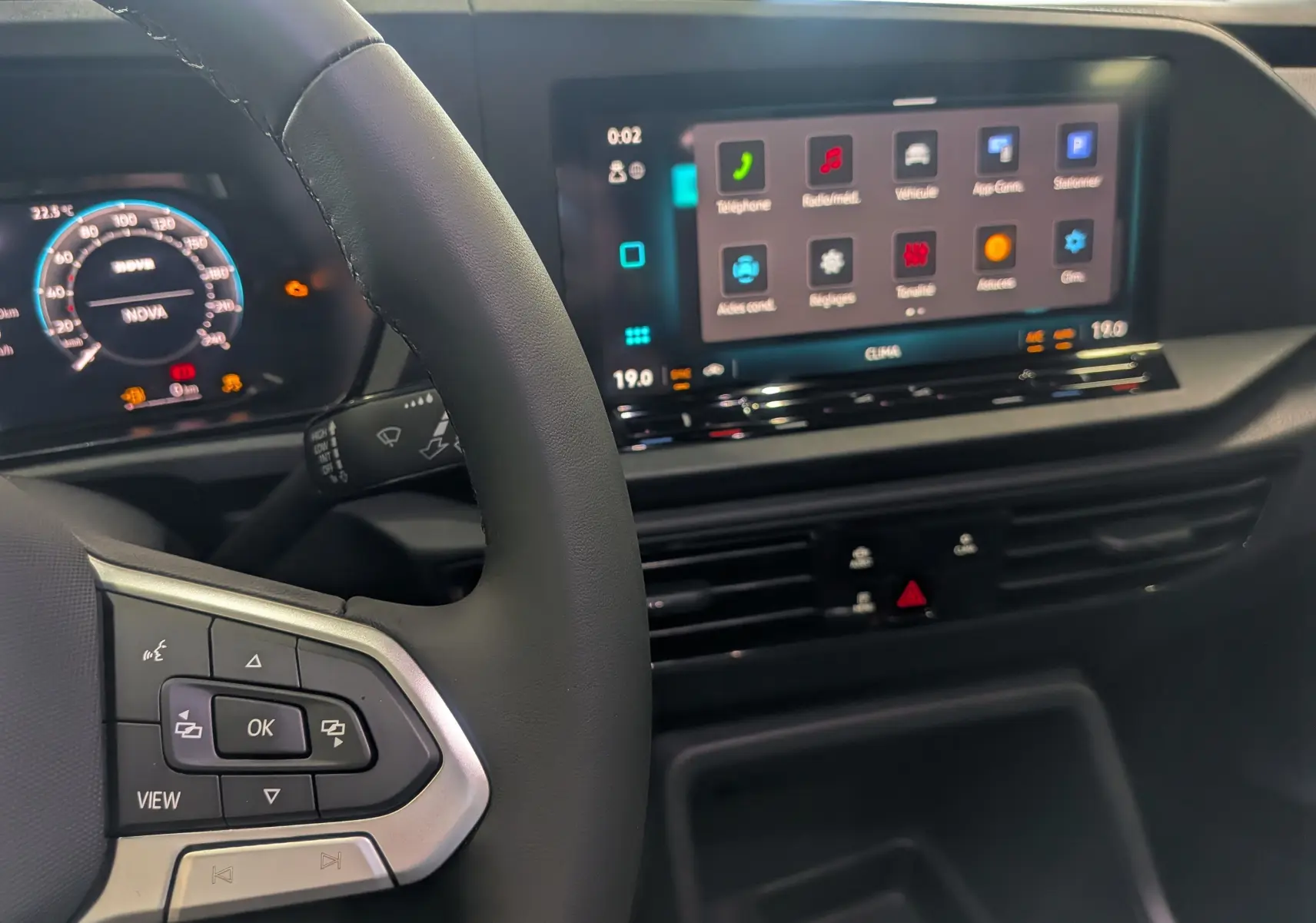 Vue intérieure du tableau de bord et volant du Volkswagen Caddy 2.0 TDI 2025 avec écran tactile et commandes au volant.