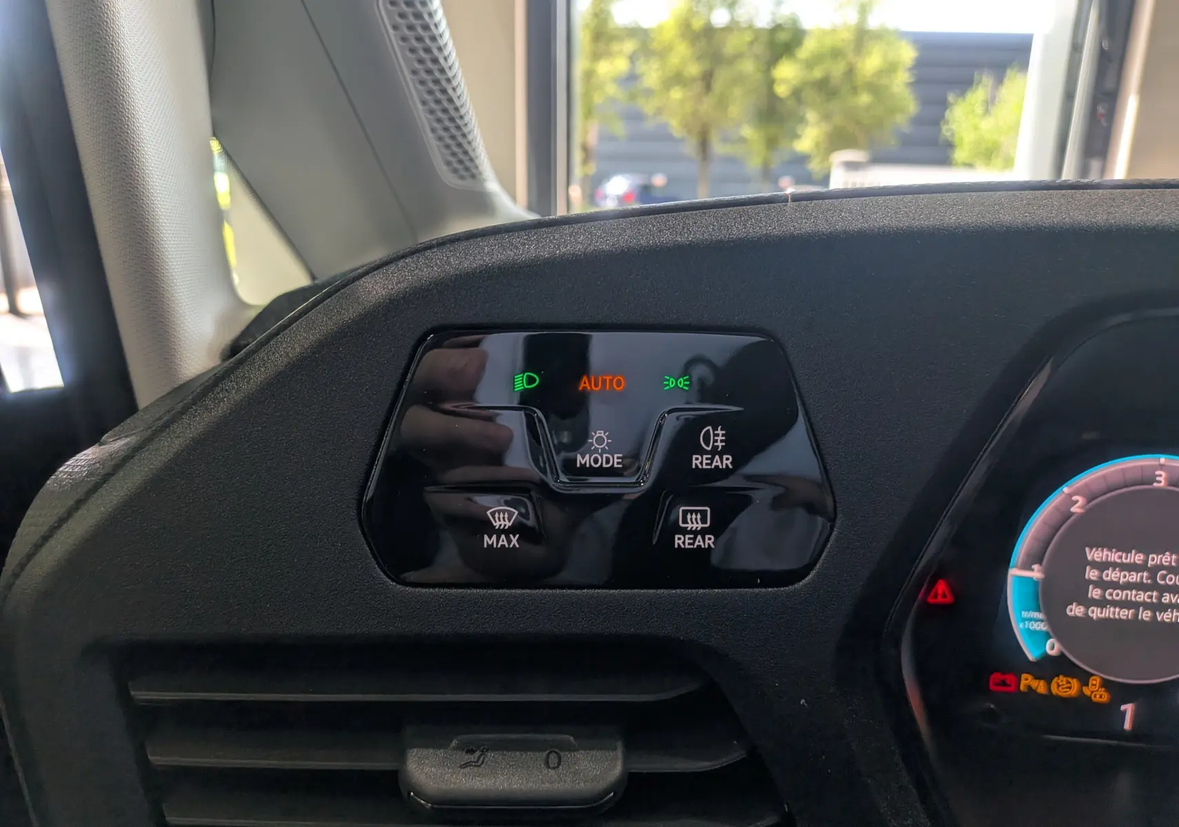 Détail du tableau de bord noir du Volkswagen Caddy 2.0 TDI 2025 montrant les commandes d'éclairage et de chauffage arrière.