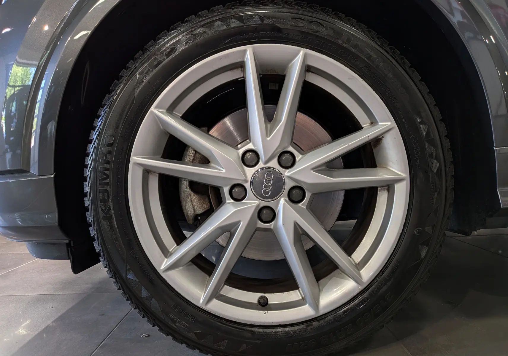 Gros plan sur la roue avant gauche grise d’un Audi Q2 1.4 TFSI S-Line, avec jante en alliage à 5 doubles branches.