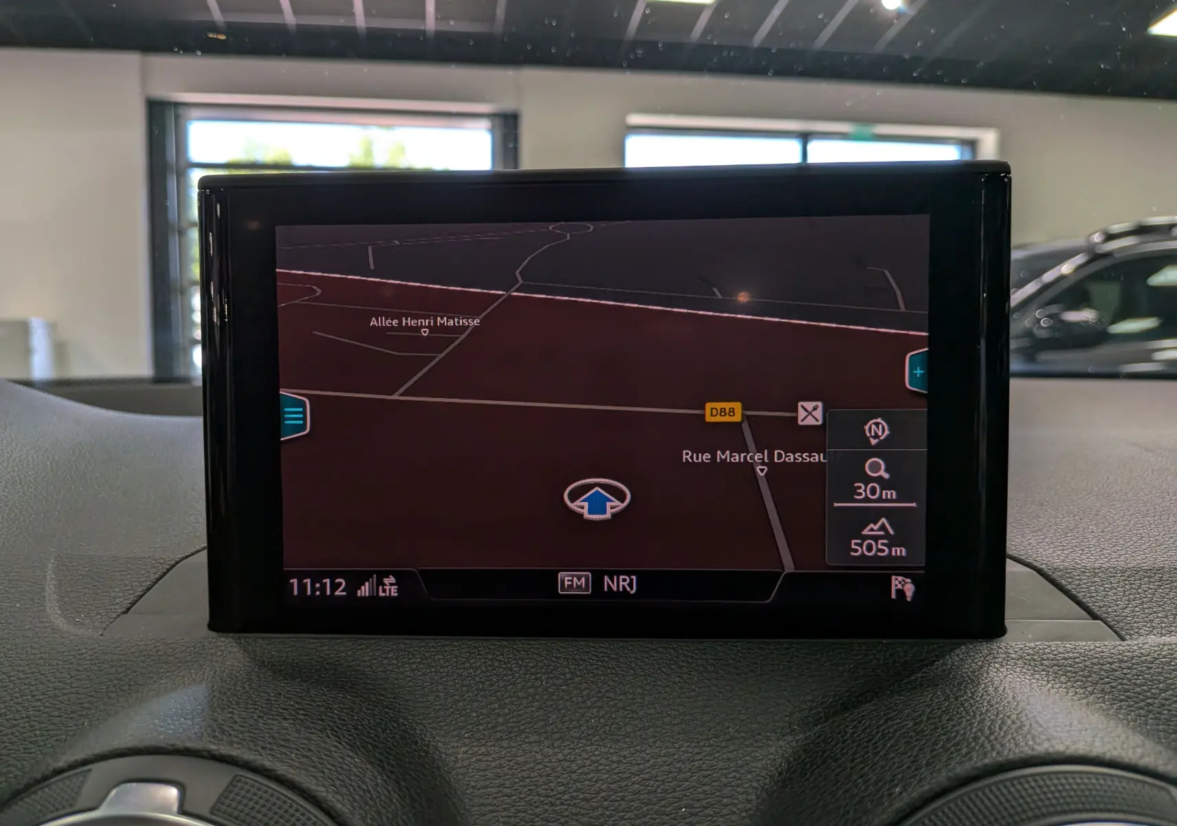 Écran central du système de navigation de l’Audi Q2 2017 affichant une carte avec itinéraire en intérieur gris.