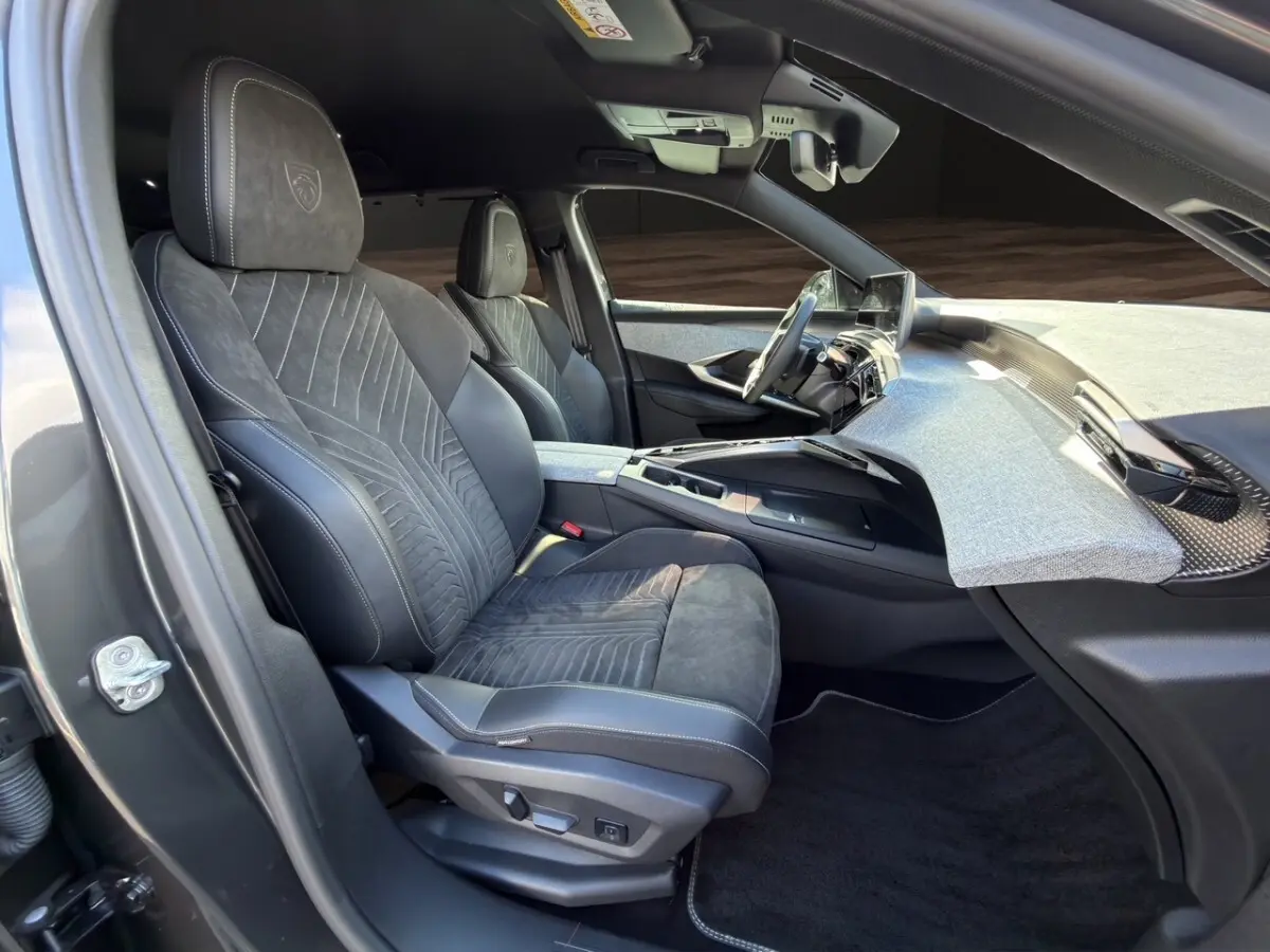 Vue intérieure côté conducteur du Peugeot 5008 2025, sièges Alcantara gris foncé avec logo Peugeot brodé.