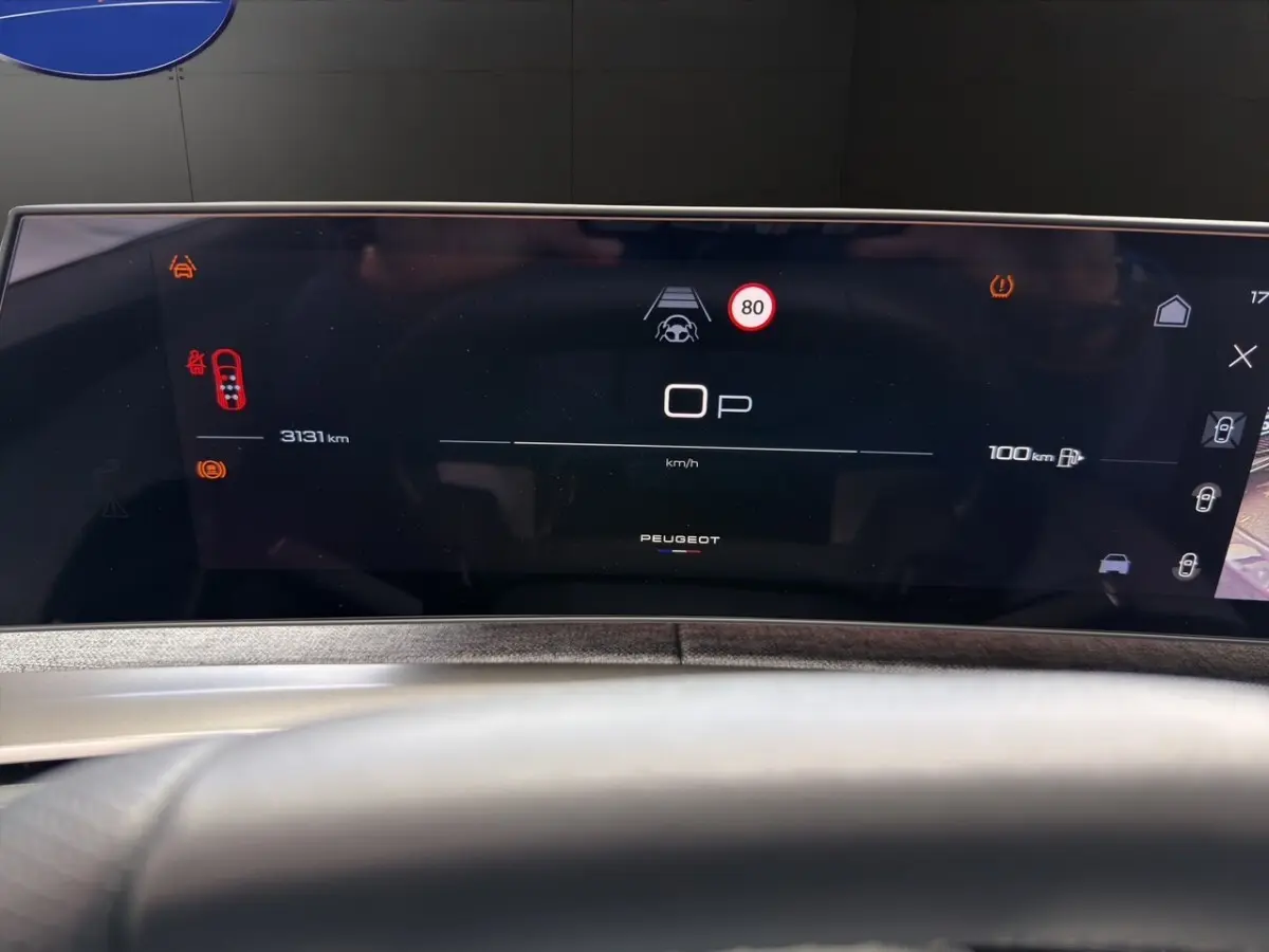 Tableau de bord numérique du Peugeot 5008 gris foncé, affichage multifonctions avec vitesse et alertes visibles.