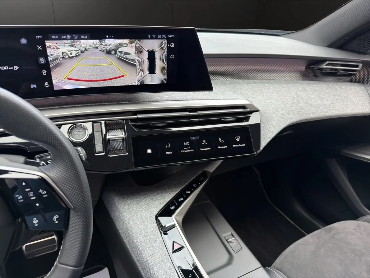 Vue intérieure du tableau de bord du Peugeot 5008 gris foncé, avec écran tactile multifonctions et volant cuir multifonction.