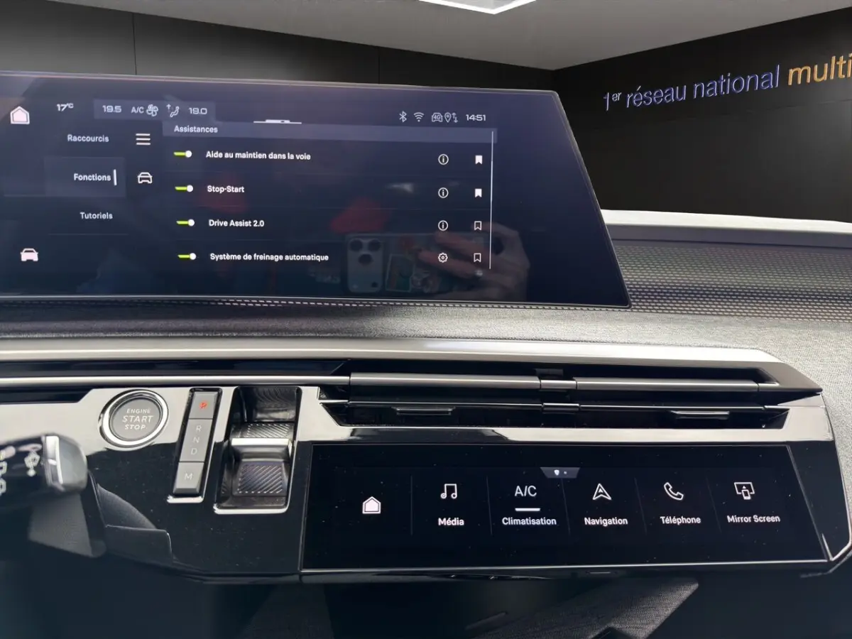 Vue rapprochée de la console centrale du Peugeot 5008 gris foncé, avec écran tactile et commandes numériques.