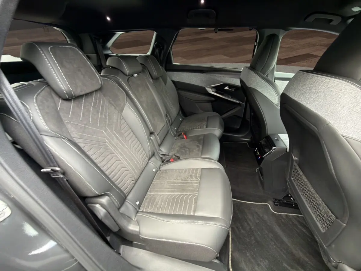 Vue intérieure côté gauche sur la banquette arrière en Alcantara gris foncé du Peugeot 5008 2025 hybride.
