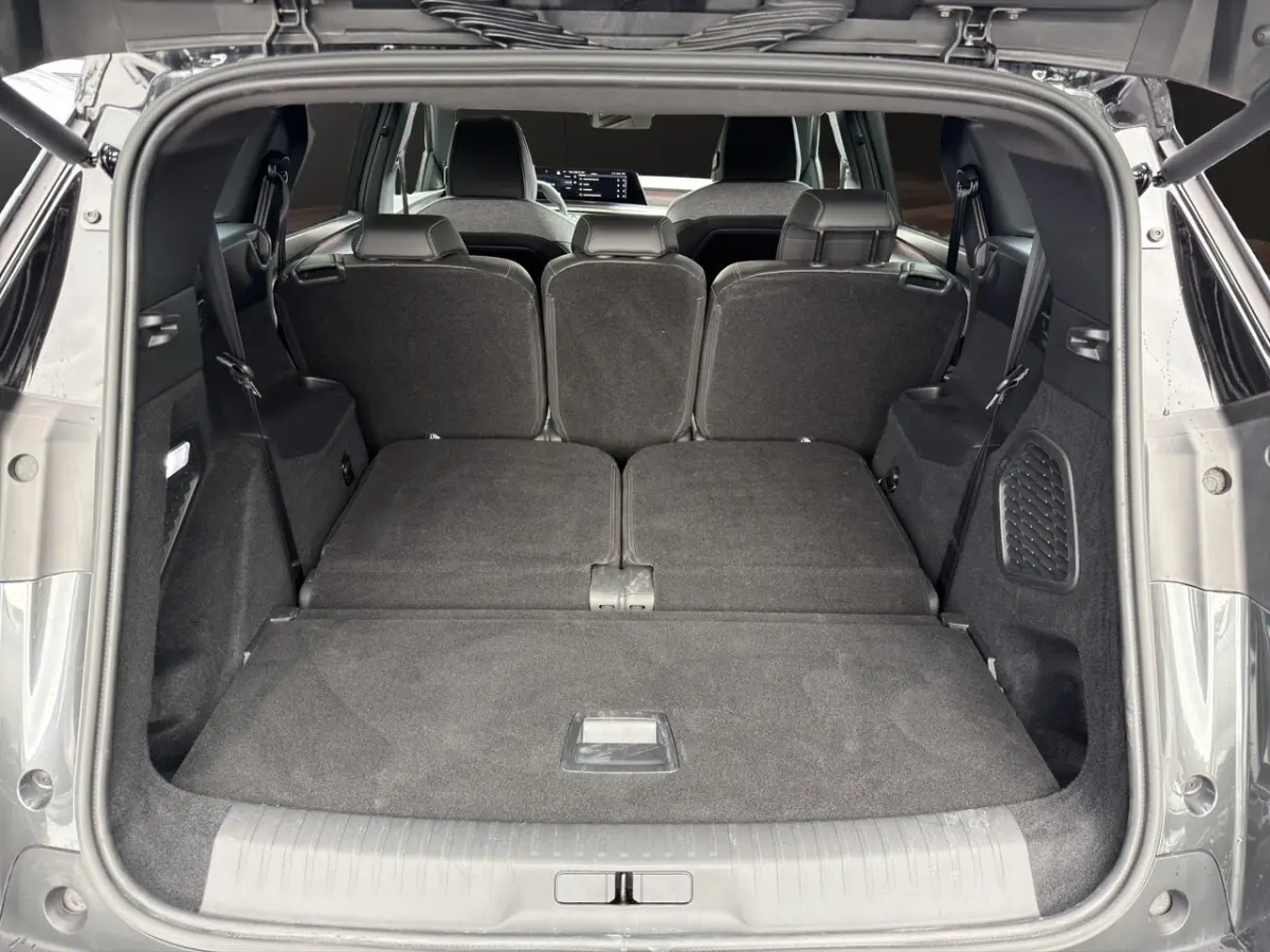 Coffre ouvert du Peugeot 5008 gris foncé, vue arrière montrant la 3ème rangée de sièges rabattue à plat.