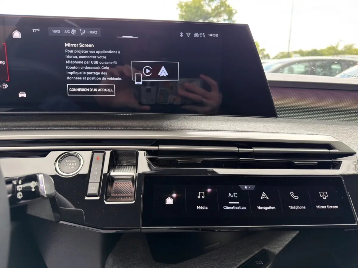 Vue intérieure du tableau de bord du Peugeot 5008 2025, avec écran tactile large et commandes modernes en noir brillant.