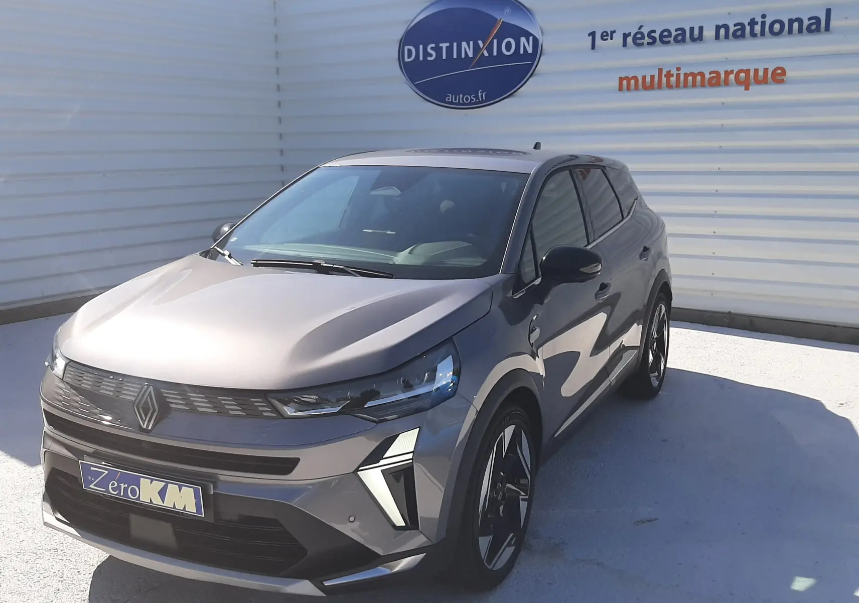 Renault Symbioz gris cassiopée en 3/4 avant droit, SUV hybride avec phares LED et jantes noires distinctives.