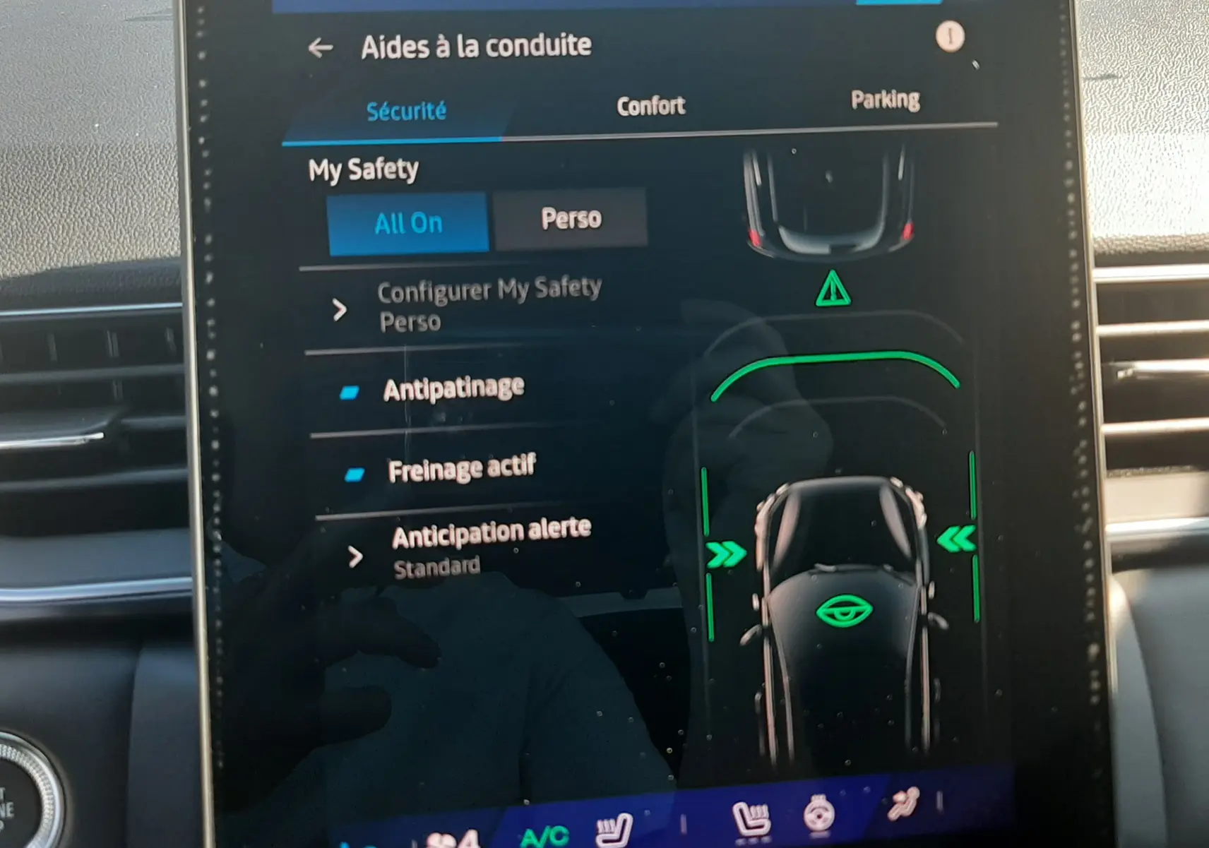 Écran tactile central du Renault Symbioz 2025 affichant les aides à la conduite avec interface moderne et détails verts lumineux.