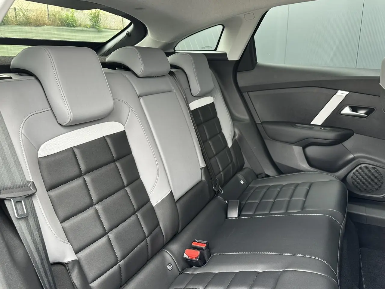 Vue intérieure côté droit des sièges arrière en cuir noir et gris clair de la Citroën C4 NV Hybrid 2025