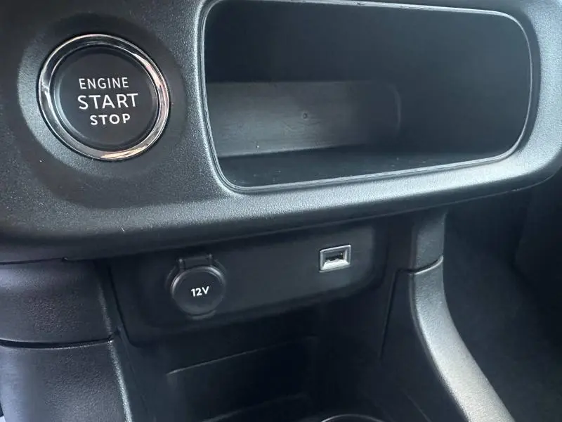 Détail intérieur de la Citroën C3 2023 montrant le bouton Start/Stop, prise 12V et port USB sur la console centrale noire.