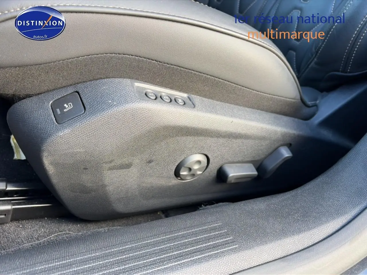 Gros plan sur les commandes de réglage électrique du siège avant droit en cuir noir du Peugeot 508 Hybrid 225 GT e-EAT8 gris titane.