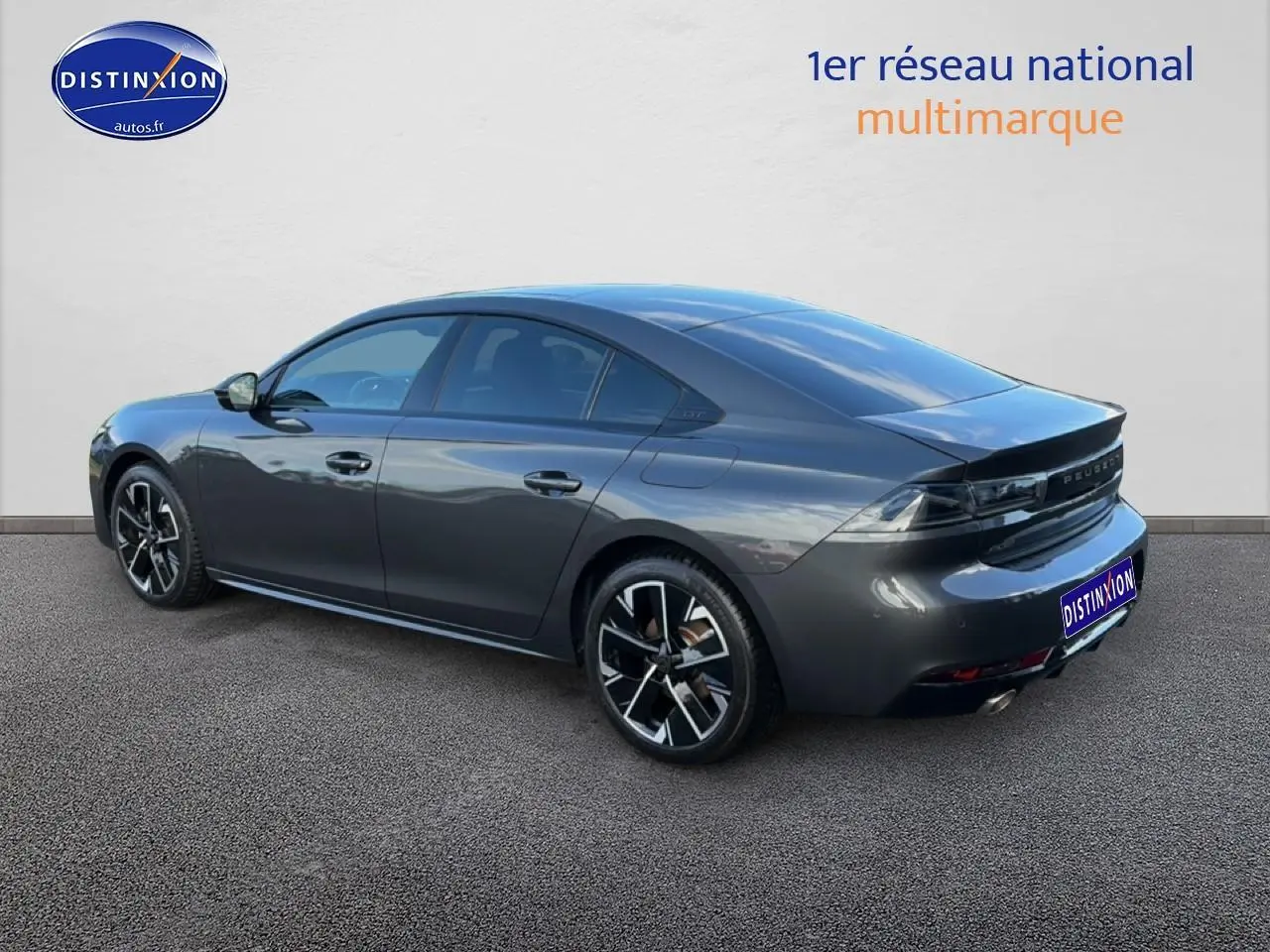 Vue 3/4 arrière droite d'une Peugeot 508 Hybrid 225 GT gris titane avec jantes alu et feux arrière LED.