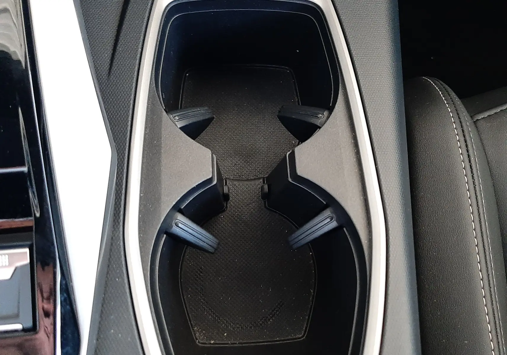 Gros plan sur les porte-gobelets centraux noirs avec contour argenté dans l’habitacle du Peugeot 5008 Hybrid 2025.
