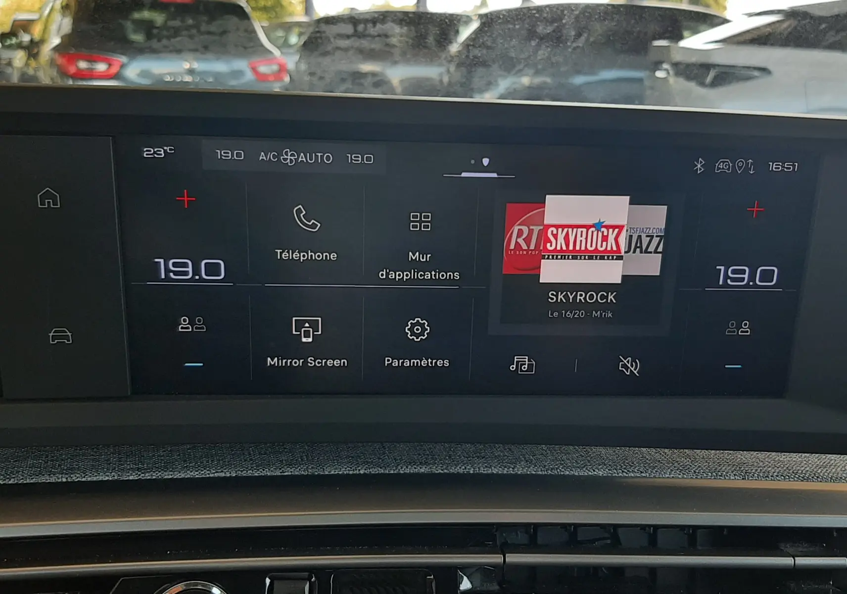 Vue intérieure du tableau de bord du Peugeot 5008 Hybrid blanc, écran tactile central affichant la radio Skyrock.