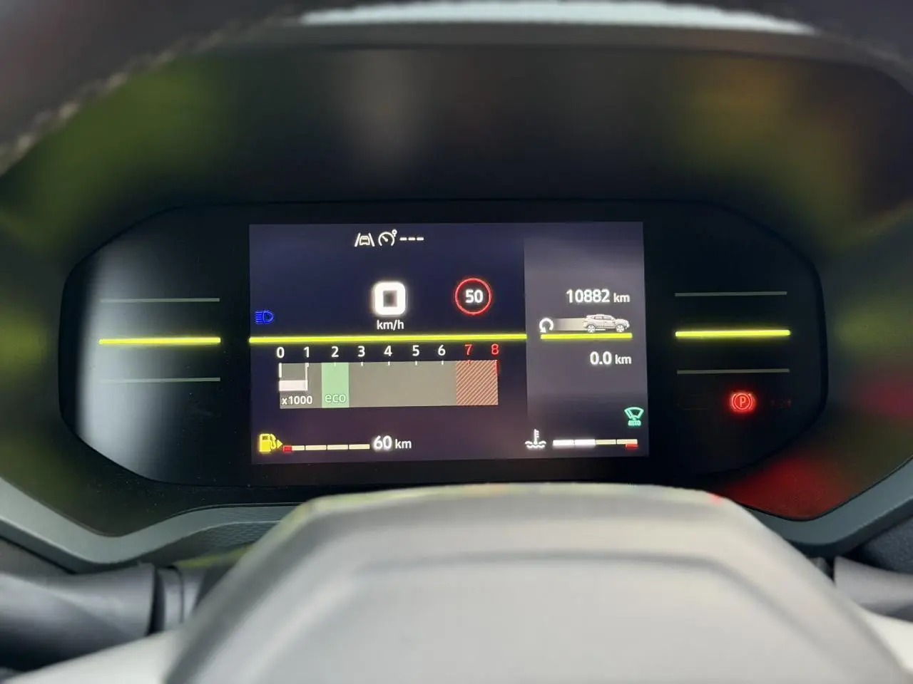 Tableau de bord digital du Dacia Duster 2025, affichage vitesse et kilométrage, vue frontale centrée.