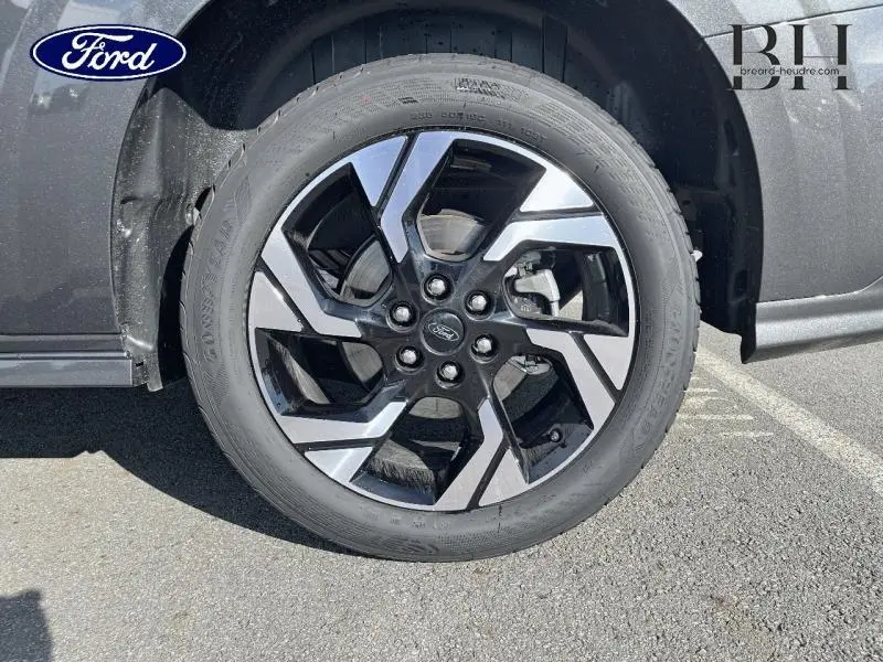 Gros plan sur la roue avant droite du Ford Transit Custom gris métallisé avec jante alu bicolore moderne.