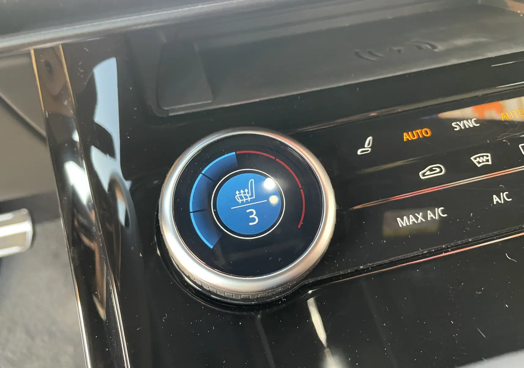 Gros plan sur la molette de réglage de la climatisation et du siège chauffant dans un Range Rover Sport Carpathian Grey 2023.