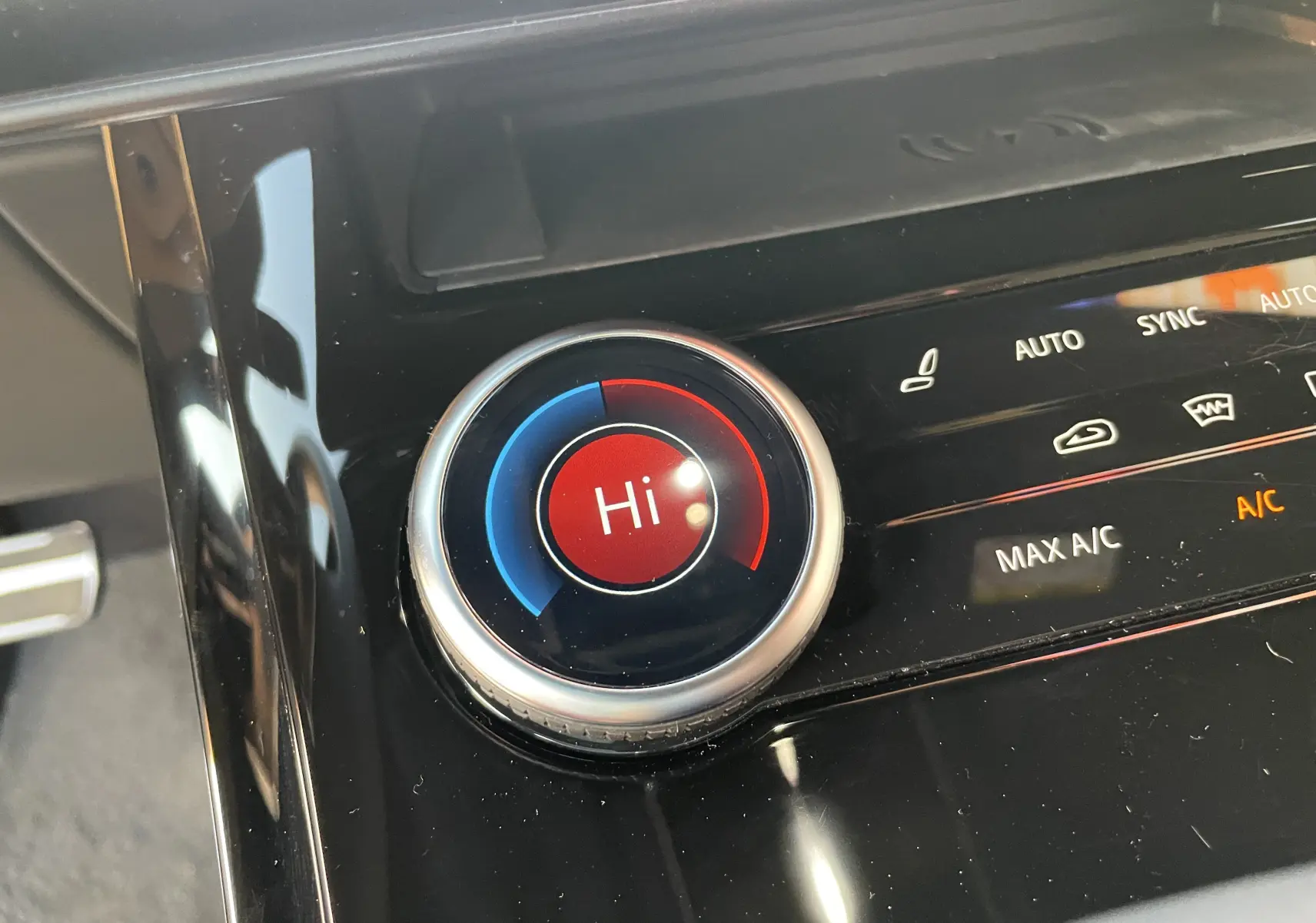 Gros plan sur la molette de réglage de la climatisation affichant "Hi" dans l'habitacle noir brillant du Range Rover Sport 2023.