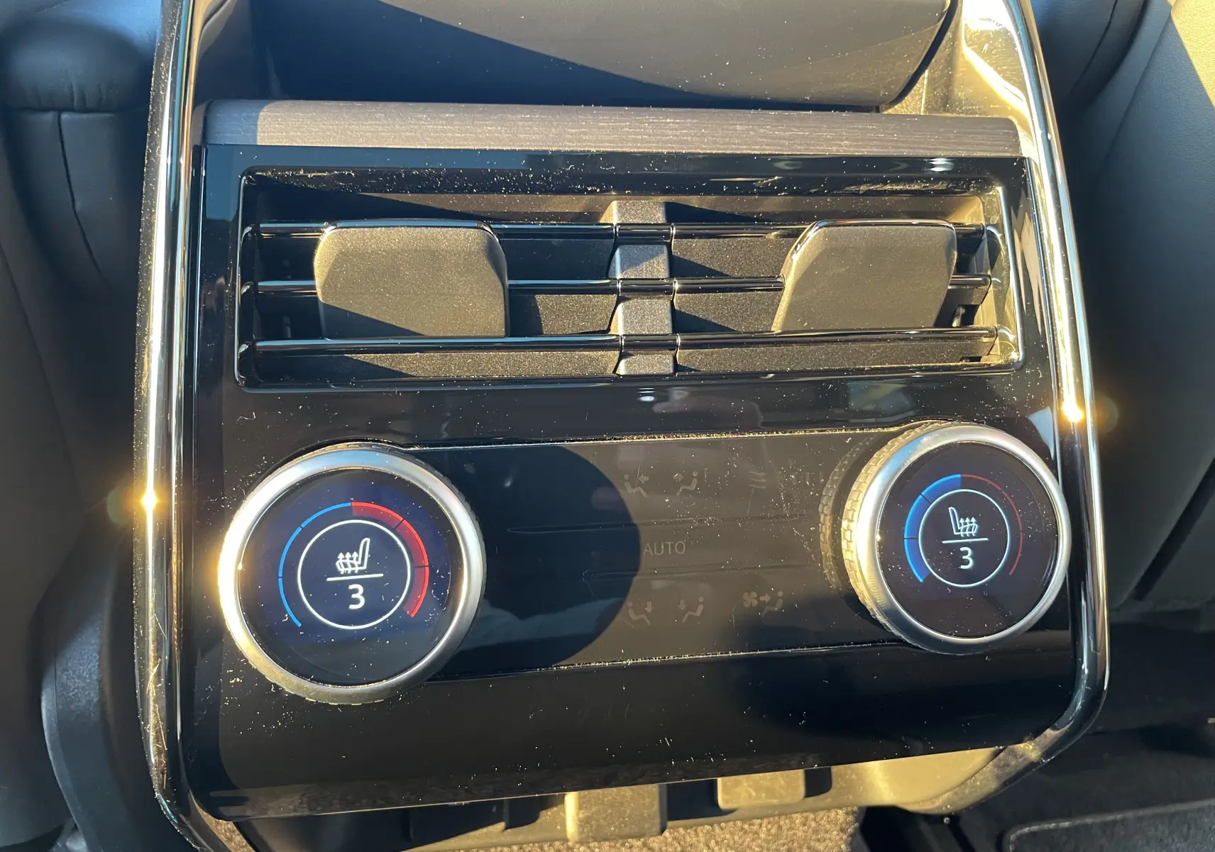 Gros plan sur la console arrière du Range Rover Sport P440 HSE R-Dynamic 2023, avec commandes de chauffage de sièges.