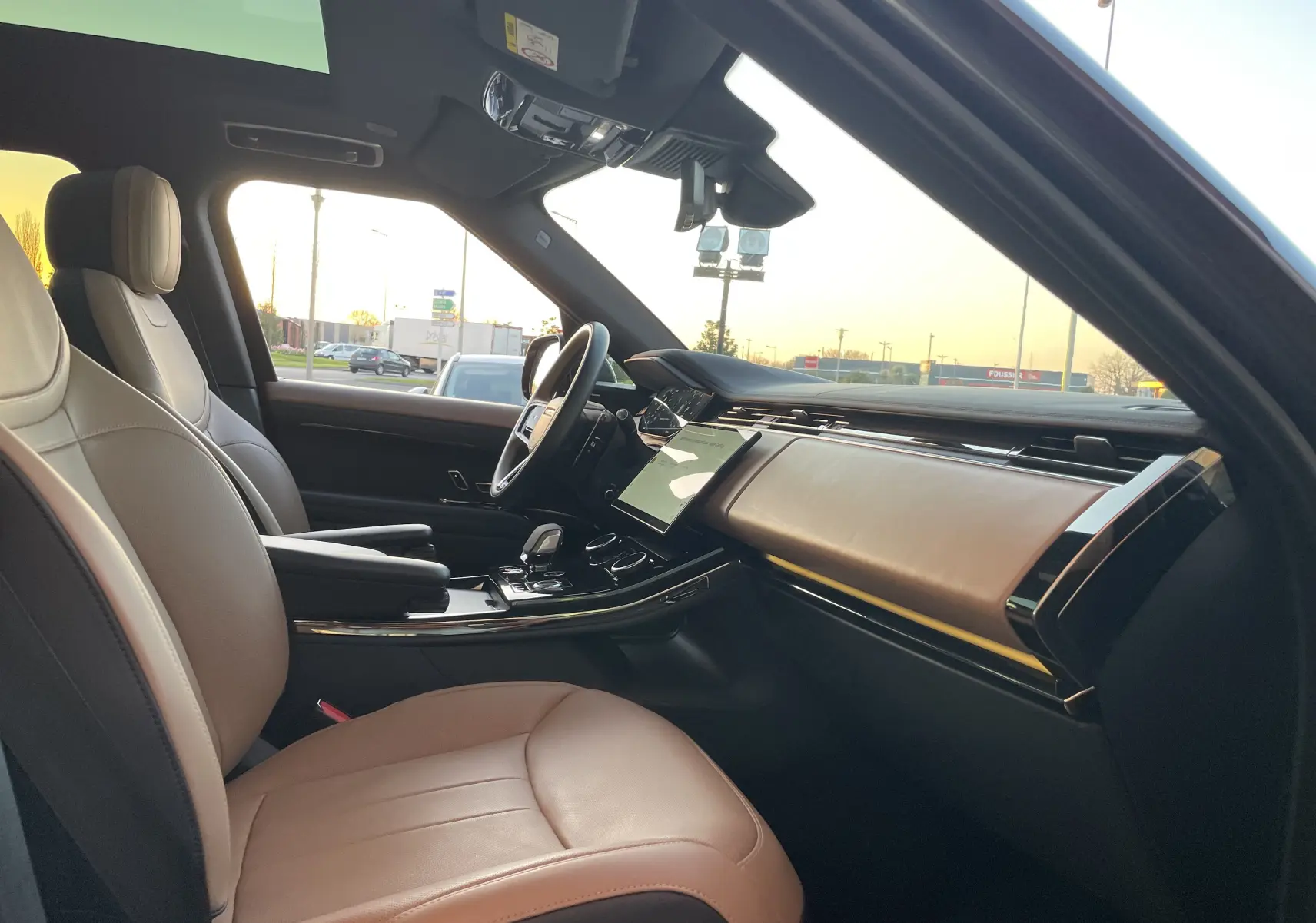 Vue intérieure côté conducteur du Range Rover Sport P440 HSE R-Dynamic 2023, sièges cuir Caraway/Ebony et tableau de bord élégant.