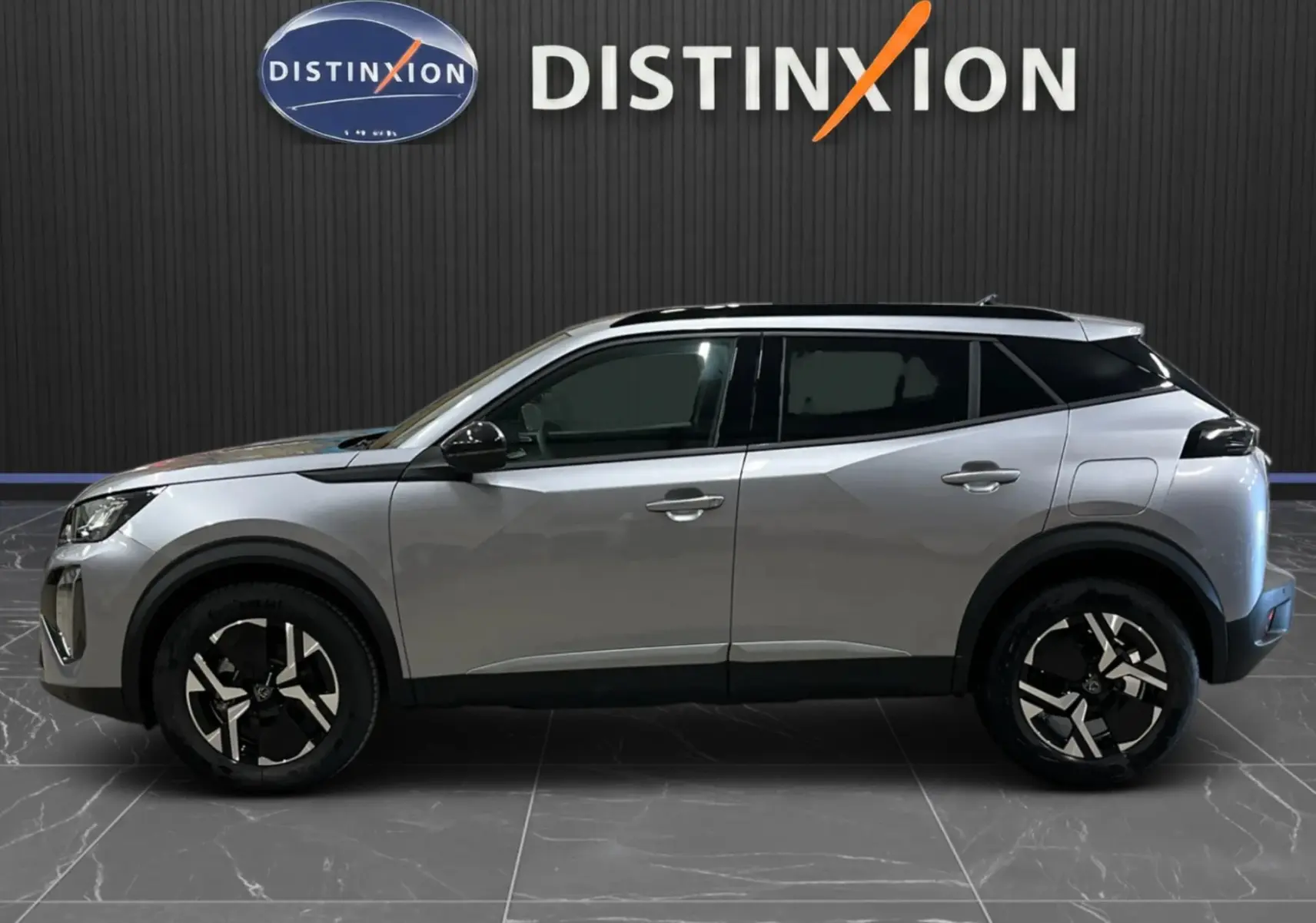 Peugeot 2008 gris Artense métal en profil droit, avec jantes bi-ton et toit noir contrasté.