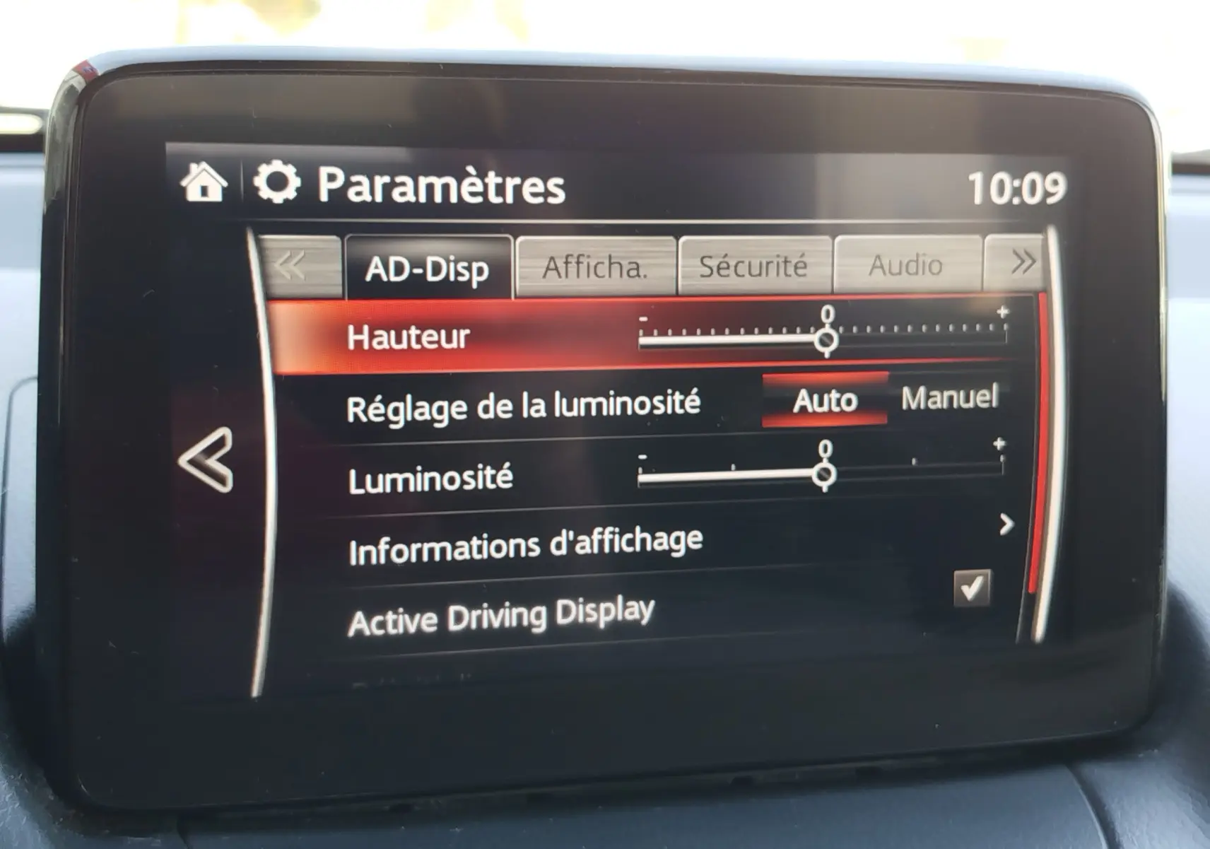 Écran central de la Mazda2 2018 affichant les paramètres de réglage de la luminosité et de l'Active Driving Display.