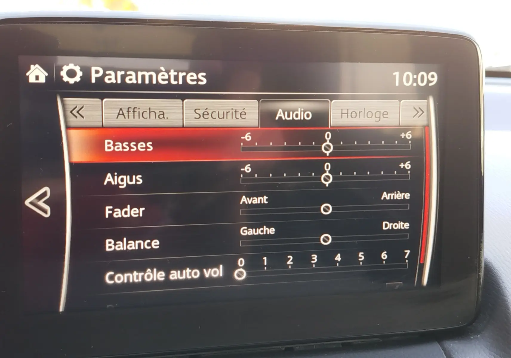 Écran central de la Mazda2 2018 affichant les réglages audio avec basses, aigus, fader et balance.