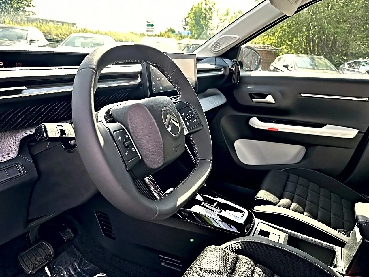 Vue intérieure côté conducteur du Citroën C3 Aircross 2026, volant multifonction et tableau de bord moderne noirs.