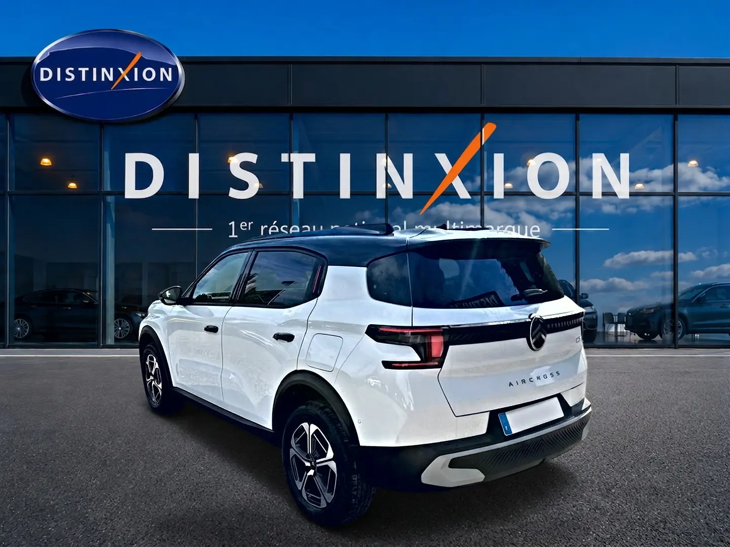 Vue 3/4 arrière droite du Citroën C3 Aircross blanc avec toit noir, feux arrière LED et jantes alu distinctives.
