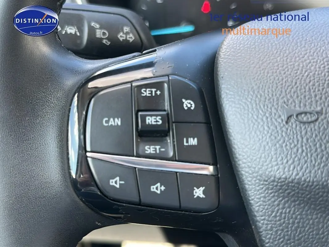 Gros plan sur les commandes du régulateur de vitesse et du volume au volant d'une Ford Focus Active gris foncé 2021.