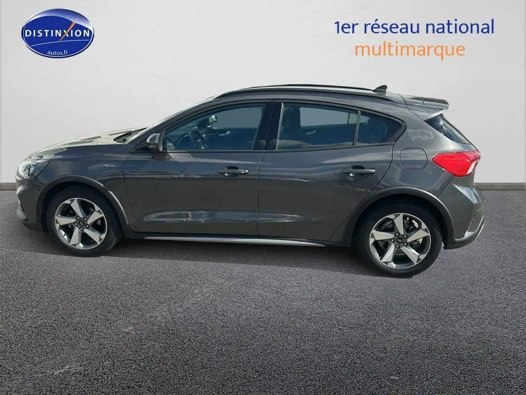 Profil côté gauche d'une Ford Focus Active gris foncé avec barres de toit et jantes alliage 17 pouces.
