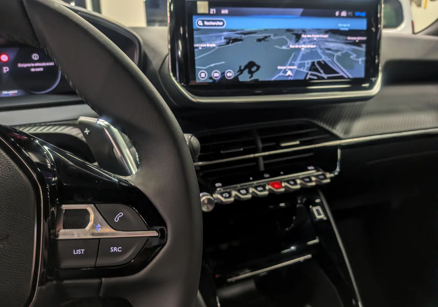 Intérieur du Peugeot 2008 Hybrid 145 e-DCS6 Allure 2025, vue sur le volant et l'écran tactile avec navigation affichée.