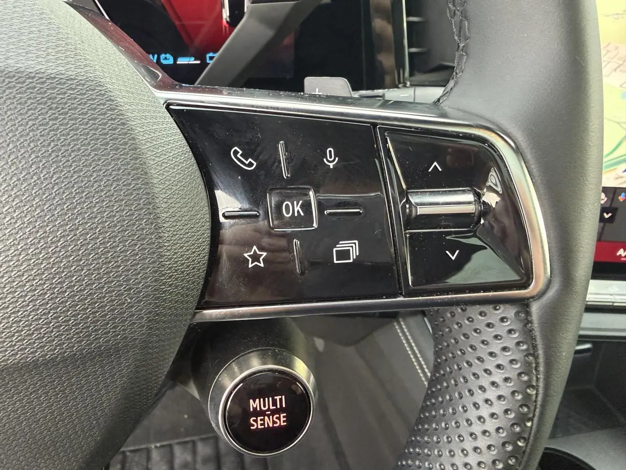Gros plan sur les commandes au volant côté droit du Renault Austral 2025, volant en textile grainé noir.