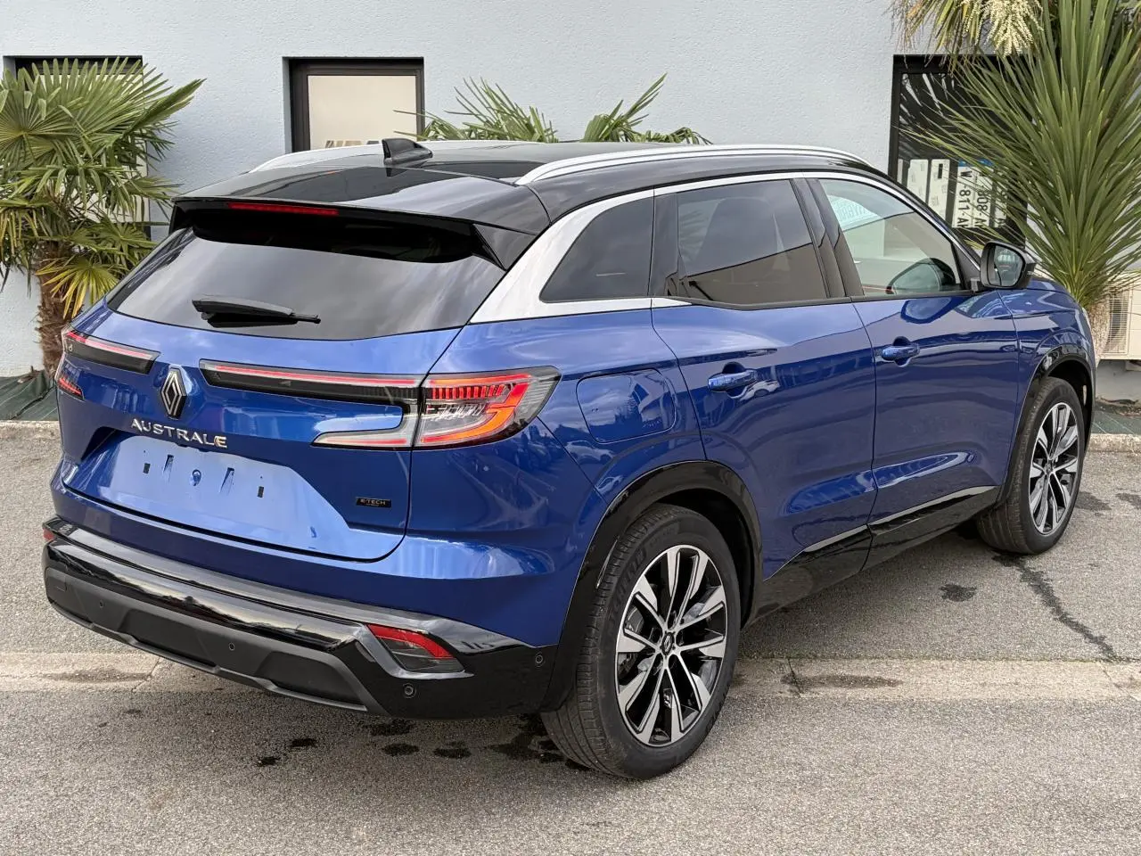 Vue 3/4 arrière droite du Renault Austral bleu Iron avec toit noir panoramique et jantes alliage 19 pouces.
