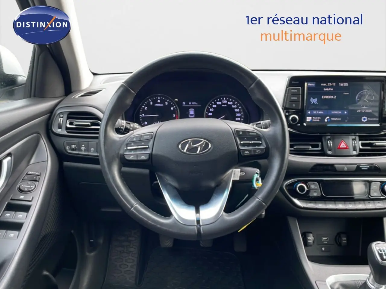 Vue intérieure centrée sur le volant et le tableau de bord du Hyundai i30 SW 2022 avec écran tactile et commandes au volant.