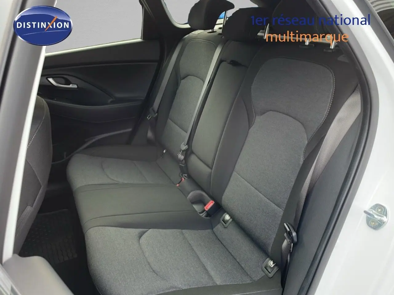 Vue intérieure côté droit montrant la banquette arrière en tissu gris d'une Hyundai i30 SW blanc atlas 2022.