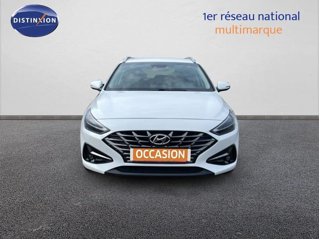 Vue avant d'une Hyundai i30 SW 1.5 T-GDI 160CH SMART blanche Atlas avec calandre noire et phares LED.